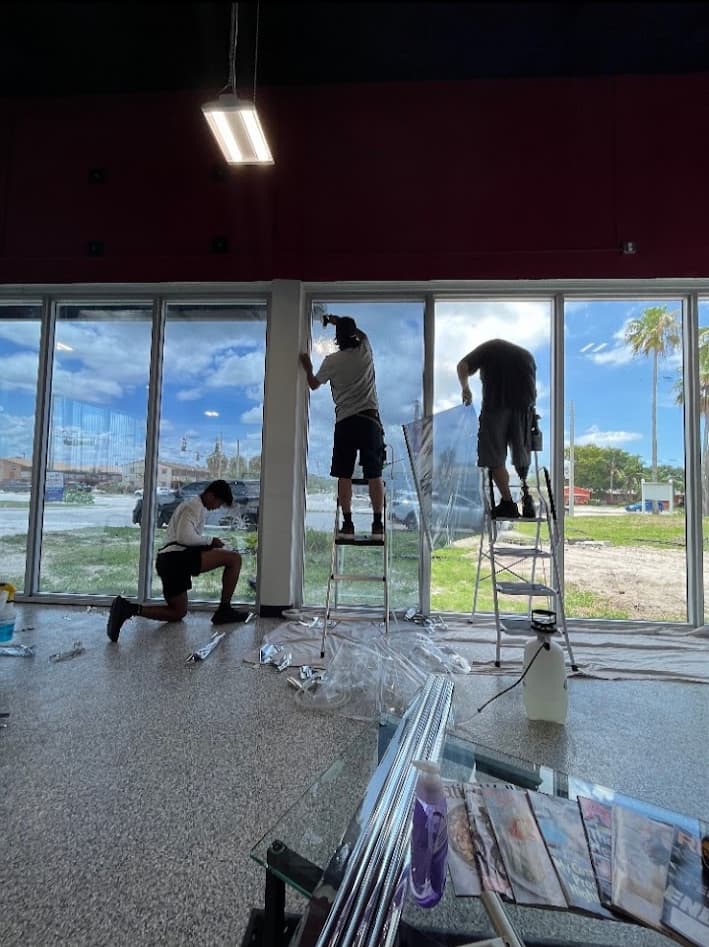 Team installing commercial window film on large storefront