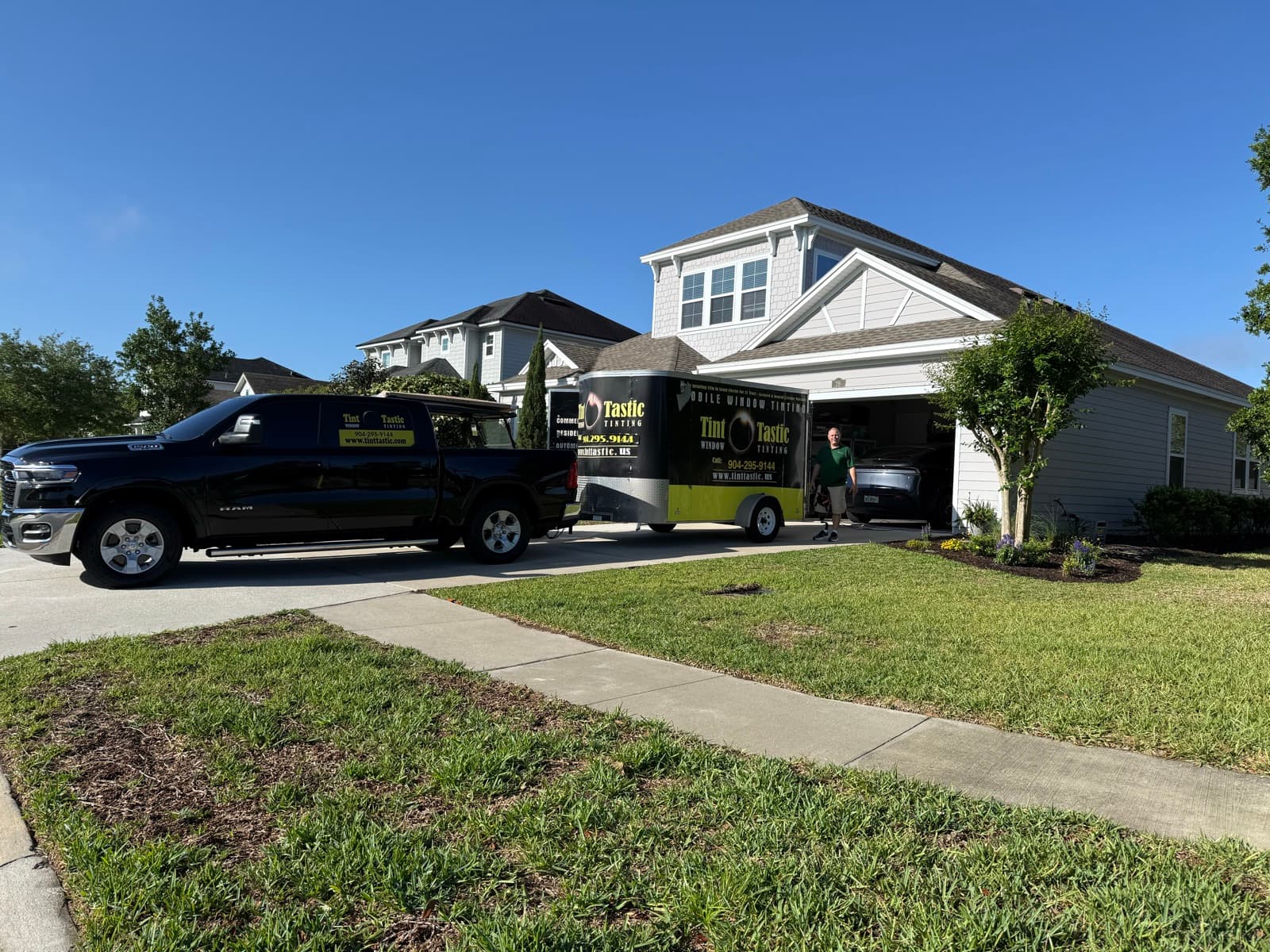Tint Tastic truck and branded trailer parked at a customer's home for an in-home installation